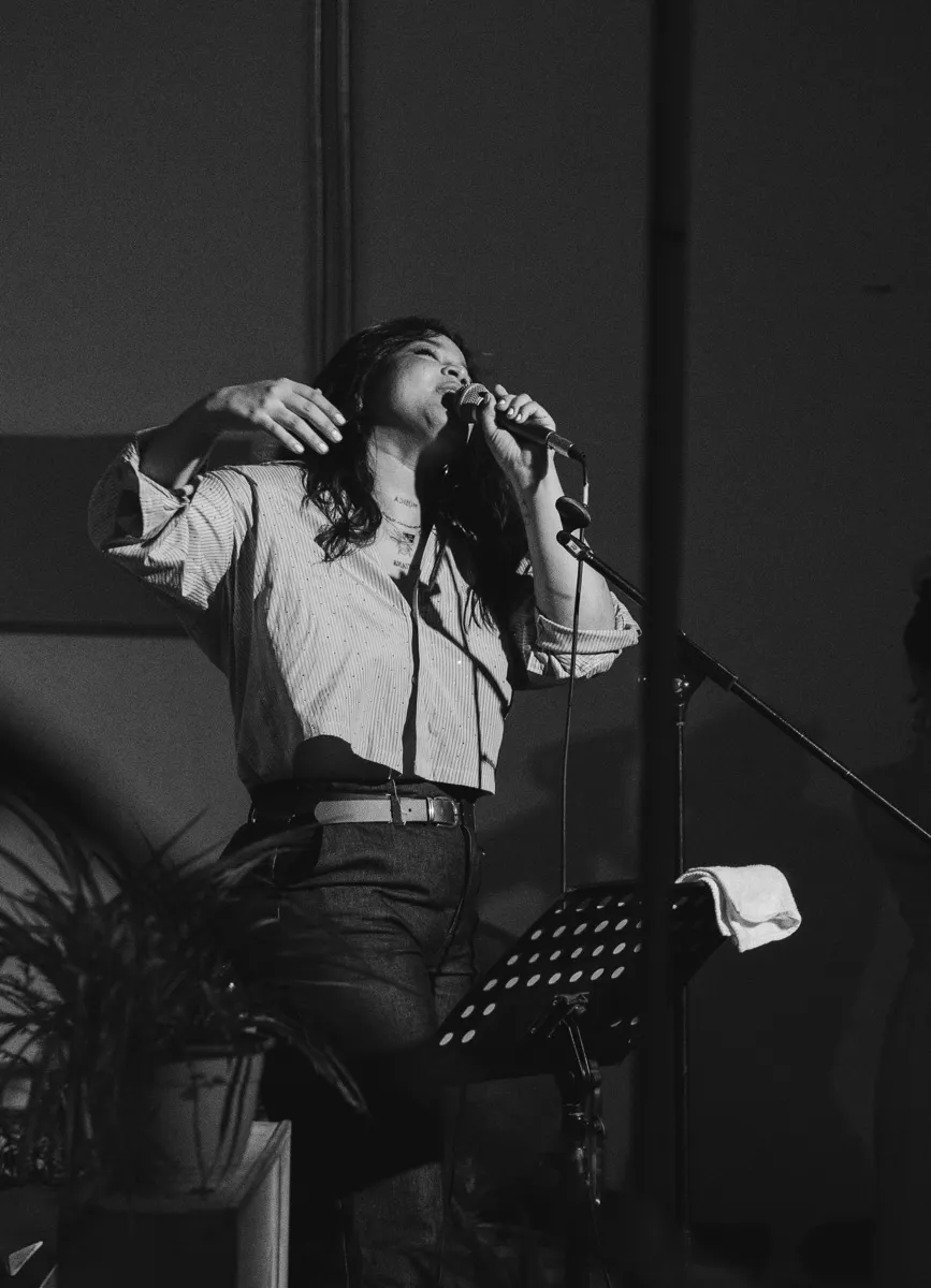 Nadieska cantando en directo frente al micrófono.
